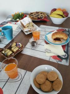 a table with plates of food and glasses of orange juice at b&b la vecchia 500 in Pignola