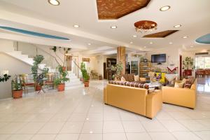 a large living room with couches and tables at Hotel Diamond in Limenaria