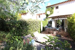 a garden with a patio with a table and chairs at Saint-Tropez walking distance, sea view house in Saint-Tropez