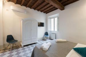 フィレンツェにあるF6 - Santa Croce one bedroom flat for 2 or 3 guestsの白いベッドルーム(ベッド1台、椅子2脚付)