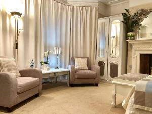 a living room with a couch and chairs and a table at Arun Sands Rooms in Littlehampton