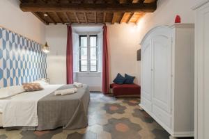 1 dormitorio con 1 cama grande y 1 sofá rojo en F7 - Santa Croce one bedroom flat for 2 or 3 guests, en Florencia