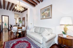 Residenza Calle Larga San Marco في البندقية: غرفة معيشة مع أريكة وطاولة