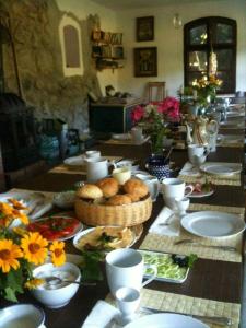 una mesa con platos de comida y flores. en Pension Jakubowo, en Jakubowo