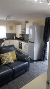 a kitchen with a black couch and a refrigerator at Ritchie selfcatering in Callander