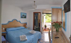 a bedroom with a blue bed with towels on it at Hotel Villa Cimmentorosso in Ischia +108 photos