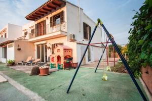 a house with a yard with a swing at Casa Svit in Portocolom