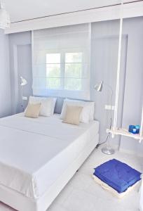 a white bed in a room with a window at Alkyoni City Apartment in Rhodes Town