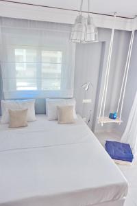 a white bed in a room with a window at Alkyoni City Apartment in Rhodes Town