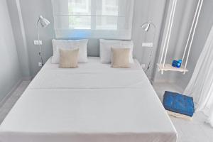 a large white bed in a room with two lamps at Alkyoni City Apartment in Rhodes Town
