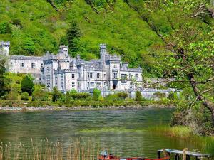 a large castle sitting on the side of a river at Bertra House B&B in Westport