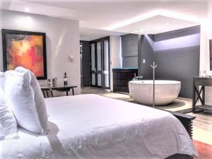 um quarto com uma cama grande e uma banheira em NEhotel Nueva Estancia em León