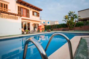 a swimming pool in front of a house at Casa Svit in Portocolom