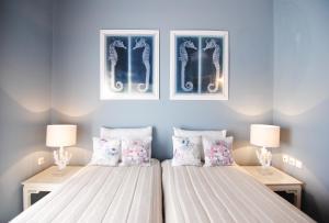 two beds in a bedroom with two lamps and pillows at Pentathlon Villa Collection - Porto Cheli Private Pool Getaways in Porto Heli +101 photos