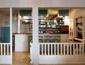 a bar in a restaurant with a counter and chairs at Drymna in Trizonia