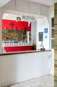 a restaurant with a red wall and a counter at Drymna in Trizonia