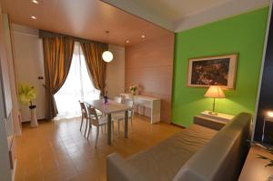 a living room with a table and a green wall at Grand Eurhotel in Montesilvano