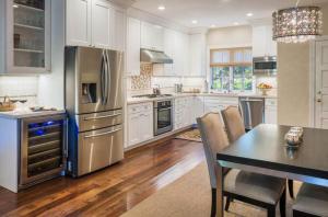 a kitchen with a table and a stainless steel refrigerator at Seal Cove Inn in Half Moon Bay