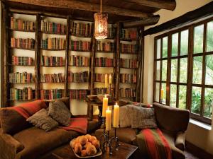 a living room with a couch and a book wall at Inkaterra Machu Picchu Pueblo Hotel in Machu Picchu