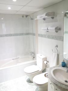 ein weißes Bad mit einem WC und einem Waschbecken in der Unterkunft Apartamento en la Ciudad de las Artes y las Ciencias in Valencia