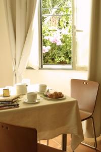 une table avec une assiette de nourriture et une fenêtre dans l'établissement Residence Villa Firenze, à Alassio