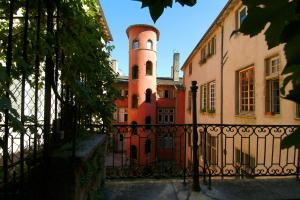 a building with a tower on top of a fence at Chambres d'hôtes Artelit in Lyon