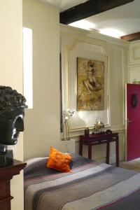 a bedroom with a bed and a painting on the wall at Chambres d'hôtes Artelit in Lyon