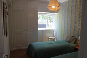 a bedroom with a bed and a window at Casa da Azarujinha in Estoril
