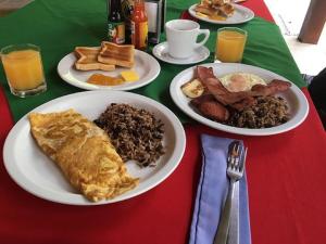 una mesa con dos platos de desayuno. en Hotel Pochote Grande, en Jacó