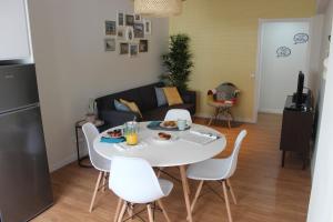 a living room with a white table and white chairs at Casa da Azarujinha in Estoril
