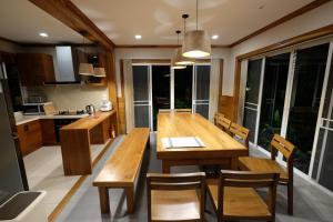 eine Küche und ein Esszimmer mit einem Holztisch und Stühlen in der Unterkunft Starry Night Villa by Zhang Bin in Chiang Mai