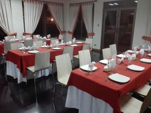 uma sala com mesas e cadeiras com toalhas de mesa vermelhas e brancas em Hotel Solaris em Huasco