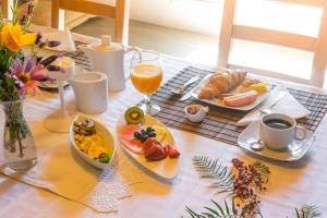 uma mesa com pratos de comida e um copo de sumo de laranja em Horta Da Coutada em Monsaraz