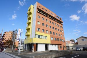 a tall building with a yellow at Hotel Sakuranbo in Yamagata