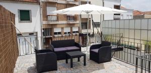 a balcony with a table and chairs and an umbrella at Enjoy Oporto Flats in Porto