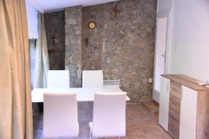 a dining room with a white table and white chairs at Ferienhaus Sonnenweg in Sankt Andrä bei Frauenkirchen