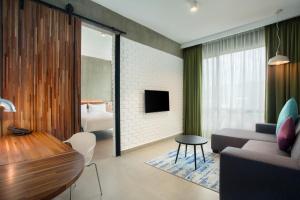 a living room with a couch and a tv at ibis Styles Kota Kinabalu Inanam in Kota Kinabalu