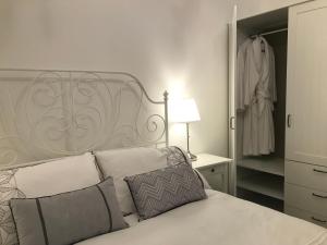 a bedroom with a white bed with pillows and a closet at Whitening Cottage in Tumbarumba