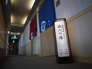 a sign in a hallway next to flags at Route Inn Grantia Hakodate Ekimae in Hakodate