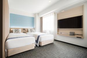 Postel nebo postele na pokoji v ubytování Tissage Hotel Naha by Nest