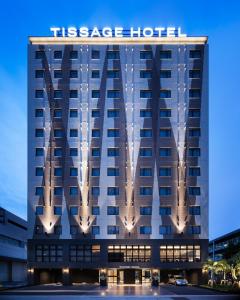 a hotel building with a sign on top of it at Tissage Hotel Naha by Nest in Naha