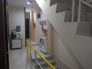 un corridoio con scala con ringhiera gialla in una stanza di Kantos Guest House a Giacarta