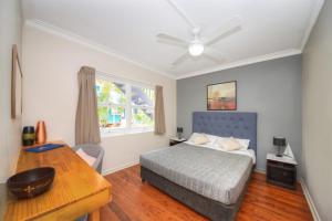 sypialnia z łóżkiem, biurkiem i oknem w obiekcie Backpackers In Paradise 18-35 Hostel w mieście Gold Coast
