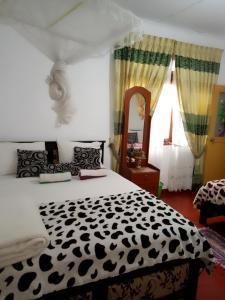 a bedroom with a black and white bed and a mirror at Tunnel Gap Homestay in Ella