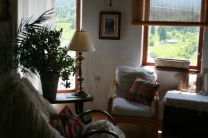 Guest house Kamenik في ياغودينا: غرفة معيشة مع أريكة وطاولة مع نبات