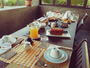 een tafel met ontbijtproducten en sinaasappelsap erop bij Domaine de La Paix in Rodrigues Island