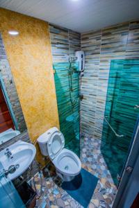 uma casa de banho com um chuveiro, um WC e um lavatório. em Na Siri Lake View em Samut Prakan