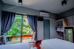 een slaapkamer met een bed en een groot raam bij Na Siri Lake View in Samut Prakan
