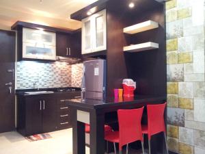 a kitchen with a table and chairs and a refrigerator at Apartemen The Suites Kayla in Bandung