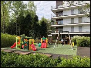 a playground in front of a apartment building at Family Apartment Golden Tulip in Międzyzdroje